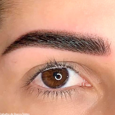 Close-up de olho castanho com sobrancelha escura bem definida