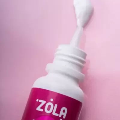 frasco branco com rótulo rosa e creme branco