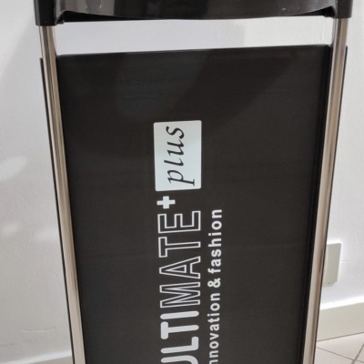Móvel de apoio preto para salão com texto 'ULTIMATE+ plus innovation & fashion'