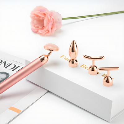 Dispositivo de beleza rosa metálico com cabeças douradas e flor rosa