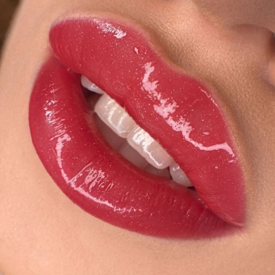 Lábios femininos com batom gloss vermelho brilhante e textura brilhante