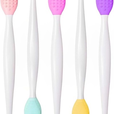 Utensílios de silicone coloridos com cabos brancos em fundo branco.