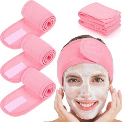 Faixas cor-de-rosa para cuidados faciais e faixa de cabelo com mulher a usar máscara branca