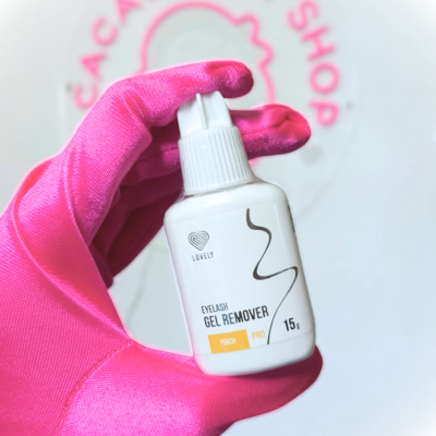 Frasco branco de removedor de gel para pestanas com rótulo e mão com luva rosa a segurá-lo.