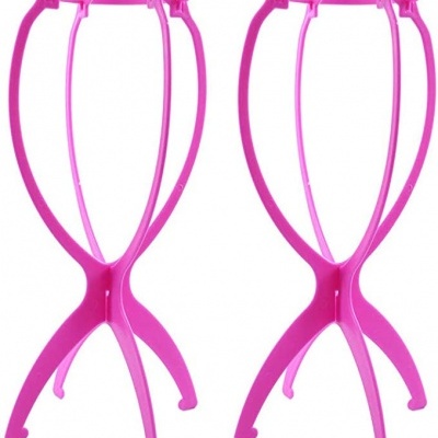 Suportes de plástico rosa para perucas em fundo branco