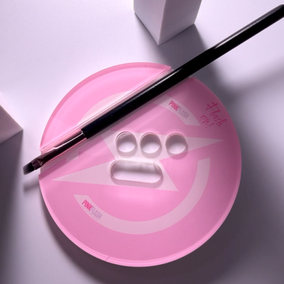 Paleta rosa redonda para maquilhagem com pincel e caixas brancas ao fundo