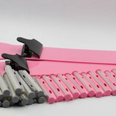 Peças de montagem rosa e cinza com garras pretas em fundo branco