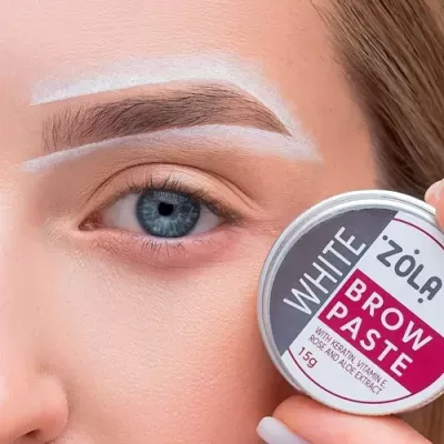 Rosto feminino com sobrancelha delineada em branco e lata de pasta para sobrancelhas ZOLA