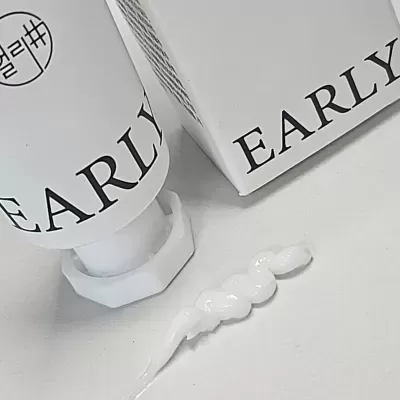 Tubo branco e caixa com texto EARLY, creme branco espesso extrudido