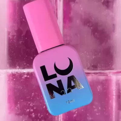 Frasco de verniz para unhas rosa e azul com texto LUNA sobre fundo rosado