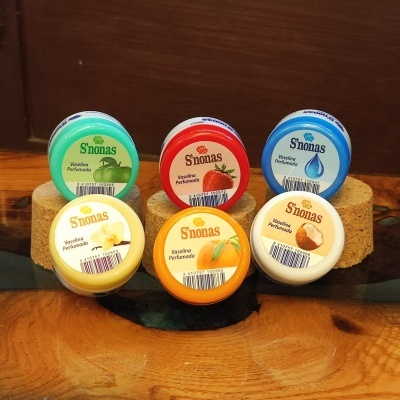 Seis frascos pequenos de vaselina perfumada S'nonas de várias cores e aromas em suportes de cortiça e madeira