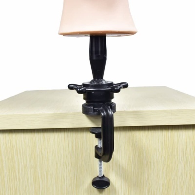 Suporte ajustável de plástico preto com busto fixado numa mesa clara