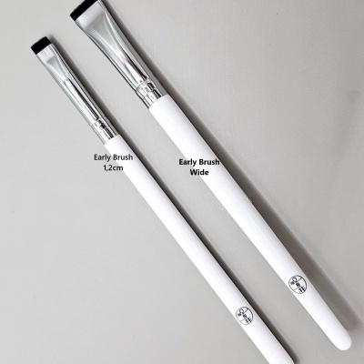 Dois pincéis de maquilhagem brancos com metal prateado, um pequeno e outro largo.