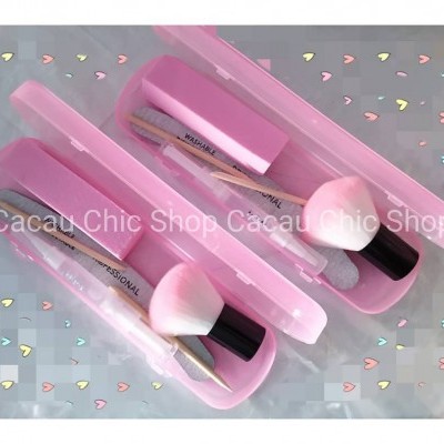 Caixas de plástico rosa com pincéis de maquilhagem e aplicadores sobre fundo branco com corações coloridos.