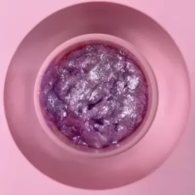 Taça rosa com sobremesa roxa brilhante sobre um prato rosa