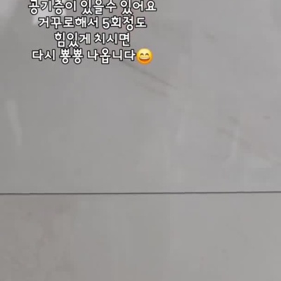 Mão segurando tubo branco e roxo de cosmético com texto em coreano
