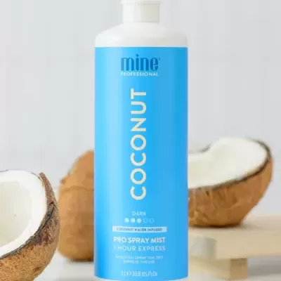 Frasco azul e branco de spray profissional de coco com cocos partidos ao fundo
