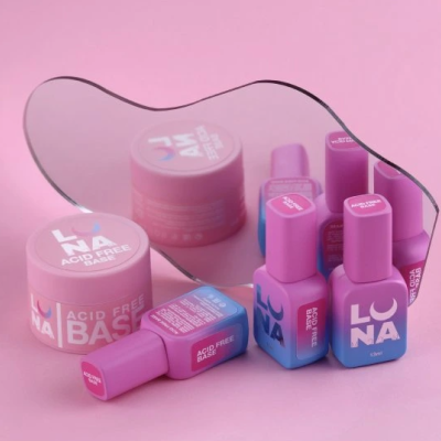 Produtos cosméticos LUNA com base acid free em frascos rosa e azul sobre fundo rosa com espelho