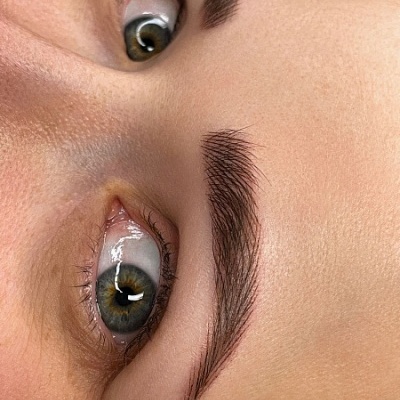 Close-up de olhos castanhos com sobrancelhas definidas e pele clara