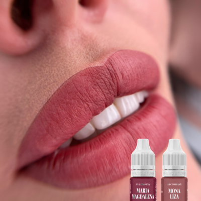 Close-up de lábios com batom rosa avermelhado e frascos de batom em fundo desfocado