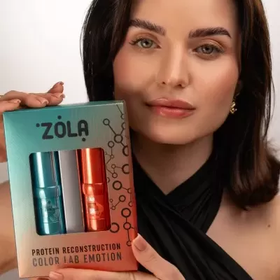 Mulher segurando embalagem ZOLA com sprays coloridos azul e laranja