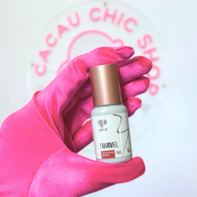 Frasco branco de cola para extensões de pestanas Marvel Pro com tampa dourada na mão com luva rosa.