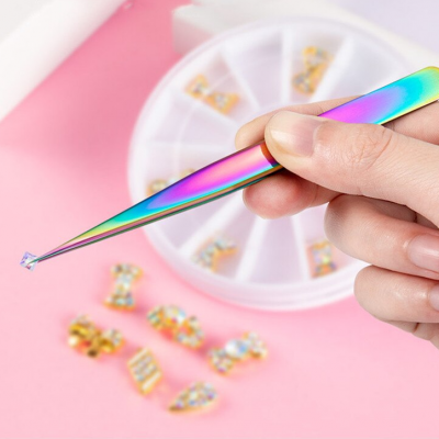 Pinça iridescente segurando pedra brilhante com roda de pedras decorativas ao fundo