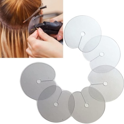 Discos transparentes de plástico com furo central e recorte, usados em aplicações capilares