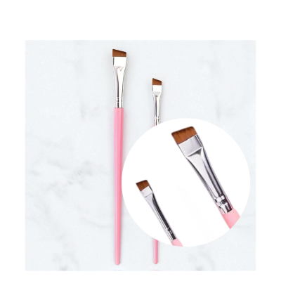 Dois pinceis maquilhagem rosa com cerdas castanhas angulares sobre fundo branco marmoreado