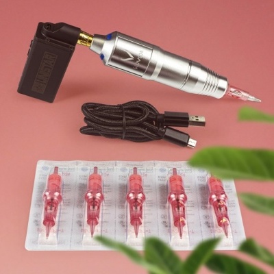 Máquina de tatuagem prateada com agulhas vermelhas e cabo USB preto sobre fundo rosa