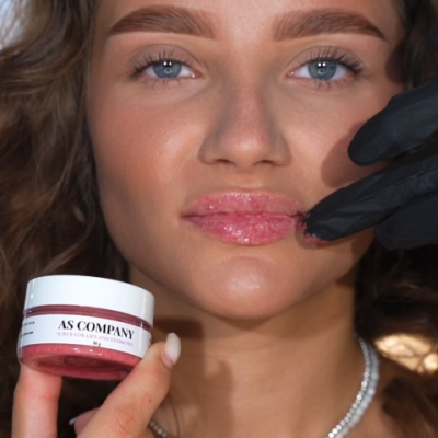 Mulher com esfoliante labial AS COMPANY aplicado nos lábios