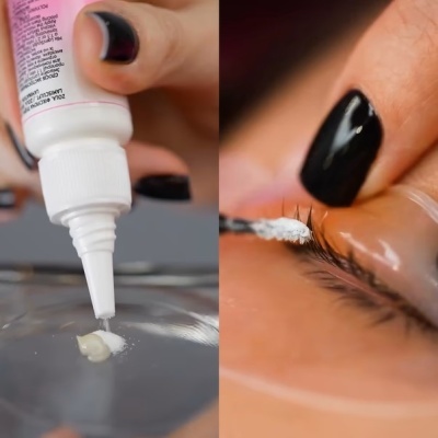 Aplicação de líquido branco da embalagem às pestanas com unhas pretas.