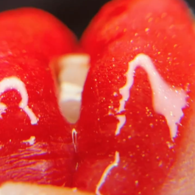 Superfície vermelha brilhante com textura granulada e fundo escuro