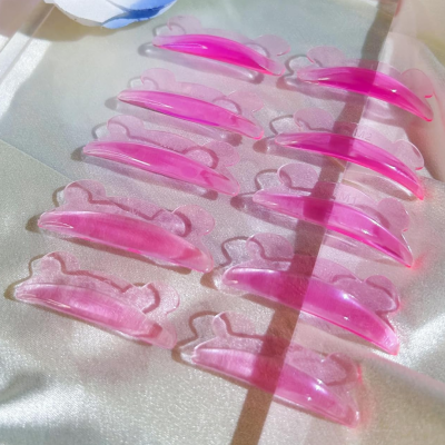 Doze ganchos de cabelo rosa transparentes sobre tecido brilhante