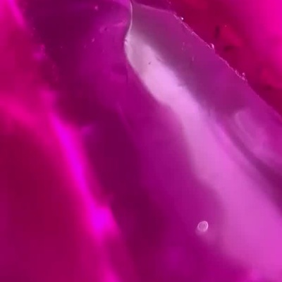 Tubo branco de cola PINK FLASH com design rosa e dourado e cola rosa a sair da ponta