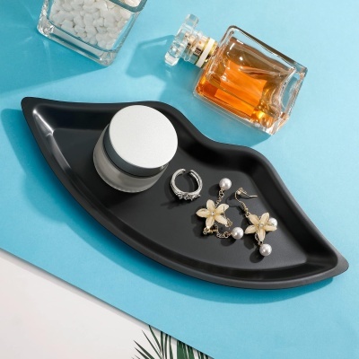 Bandeja preta em forma de lábio com produtos cosméticos e joias