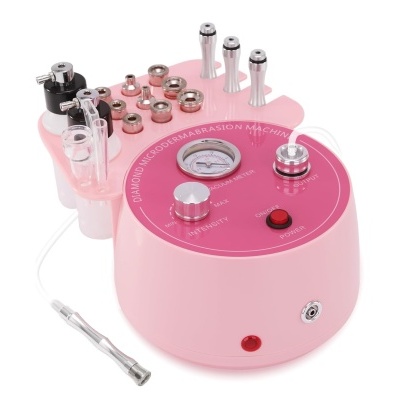 Aparelho de microdermoabrasão rosa com vários acessórios