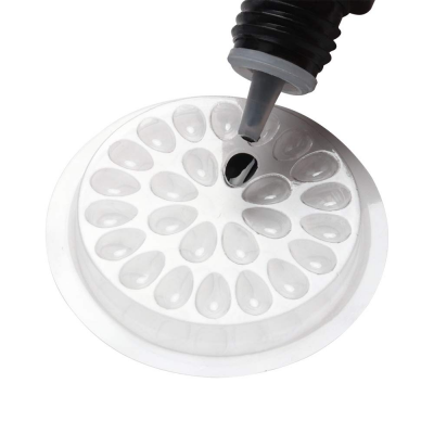 Molde redondo transparente para doces sendo preenchido com substância preta