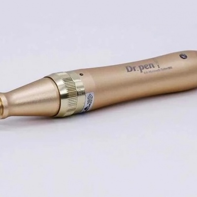 Caneta eletrónica dourada metálica Dr.pen sobre fundo branco