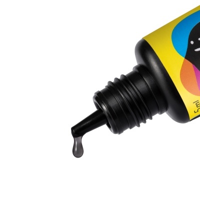 Frasco preto com líquido a sair da ponta fina e rótulo amarelo colorido