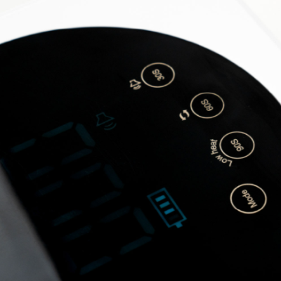 Painel de controlo de dispositivo eletrónico preto com botões brancos e ecrã azul