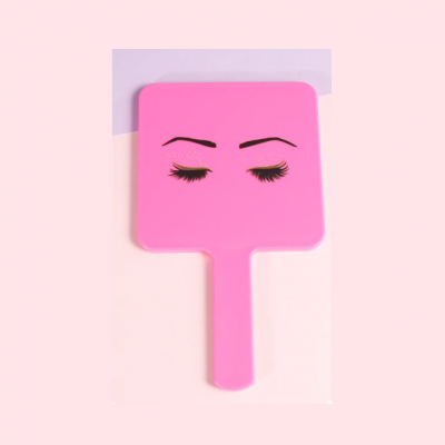 Espelho de mão rosa com desenho de sobrancelhas e pestanas