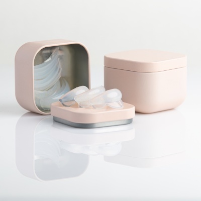 Caixas rosas claras com moldes dentais transparentes em superfície branca