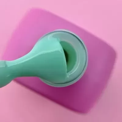 Selo adesivo verde sobre superfície cor de rosa