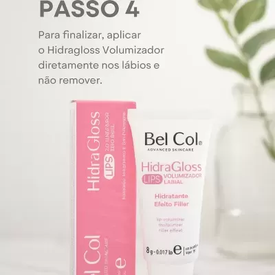 Frasco branco de HidraGloss LIPS Volumizador Labial Bel Col ao lado da caixa rosa e planta ao fundo.