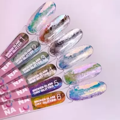 Amostras de unhas postizas com efeito glitter broken glass em várias cores num fundo rosa claro