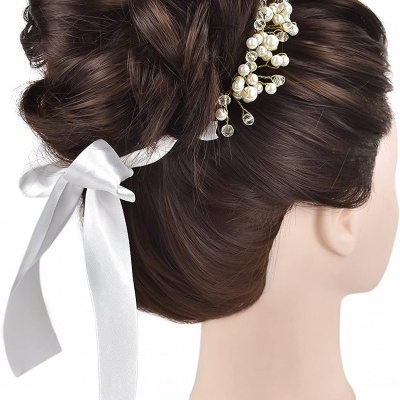 cabeça de manequim com cabelo penteado e acessório com laço branco e pérolas