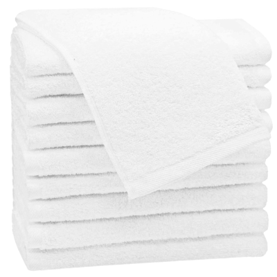 Sete toalhas de banho brancas empilhadas com uma toalha aberta no topo
