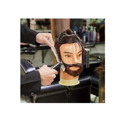 Cabeça de manequim com cabelo e barba a ser cortada numa cadeira de cabeleireiro