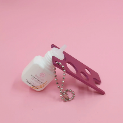 Frasco de acetona branca com suporte metálico rosa e corrente metálica